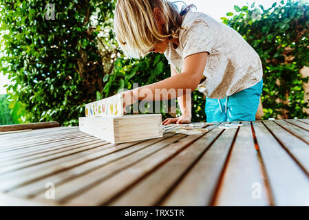 Bambino divertirsi con un educativo gioco di legno a scuola per realizzare coppie, utili per migliorare la memoria e la destrezza delle loro mani. Foto Stock