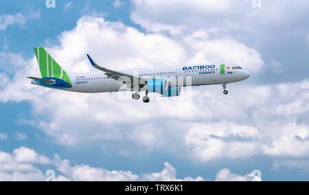 Aeroplano Airbus A321 neo Bamboo Airways volare attraverso le nuvole del cielo per preparare l'atterraggio all'Aeroporto Internazionale Tan Son Nhat di Ho Chi Minh City, Vietnam Foto Stock