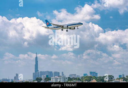 Aeroplano Airbus A320 China Southern Airlines Volare sopra le aree urbane preparare atterraggio all'Aeroporto Internazionale Tan Son Nhat di Ho Chi Minh City, Vietnam Foto Stock