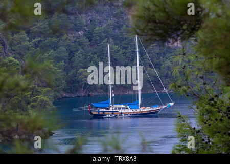 Un classico in legno tradizionale bagno turco piacere yacht ancorati in pantone in Oludeniz Golfo di Fethiye nel mare Mediterraneo contro il backdr Foto Stock