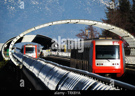 SANTIAGO DEL CILE - Giugno 2014: due Santiago metropolitana treni sulla ferrovia sopraelevata, con la montagna come sfondo Foto Stock