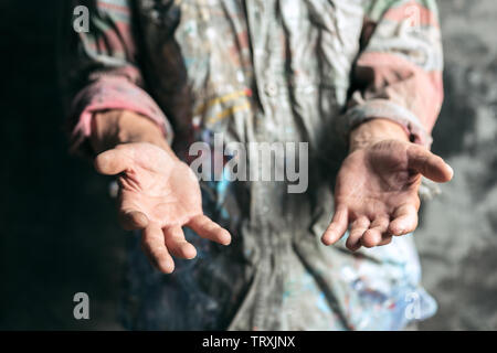 Mendicante maschio le mani in cerca di denaro, monete dalla gentilezza umana su pavimento di legno alla pubblica strada o lungo la strada pedonale. Senzatetto poveri della città. Problemi con la finanza, luogo di residenza. Foto Stock