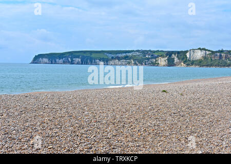 Una vista panoramica su tutta la baia a Seaton con scogliere rocciose della Jurassic Coast visto dalla spiaggia di ciottoli.distante Caravan Park affacciato sul mare. Foto Stock