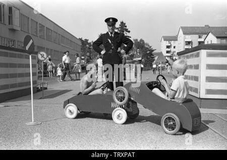 Anni Cinquanta poliziotto. Due ragazzi stanno giocando nel loro vetture del pedale e la polizia uomo guarda su quando hanno avuto un piccolo incidente. In Svezia il 7 giugno 1959 ref CV1 Foto Stock