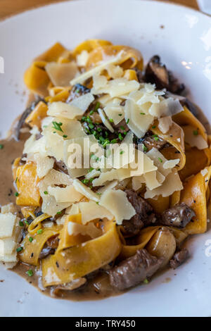 Pappardelle pasta‬‏ con carni bovine e il formaggio Parmigiano Reggiano Foto Stock