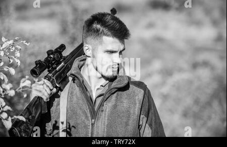 Uomo cacciatore con fucile pistola. Boot camp. Abilità di caccia e di apparecchiature di arma. Come ruotare la caccia in hobby. Uniforme militare di moda. Uomo Barbuto hunter. Forze armate. Il camuffamento. Osservando a piedi. Foto Stock