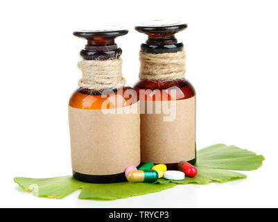 Foglie di Ginkgo biloba e medicina di bottiglie con le pillole isolato su bianco Foto Stock