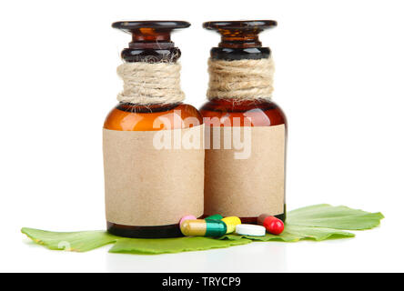 Foglie di Ginkgo biloba e medicina di bottiglie con le pillole isolato su bianco Foto Stock