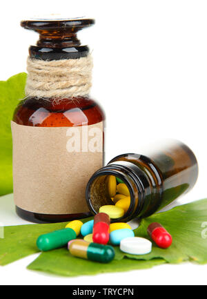 Foglie di Ginkgo biloba e medicina di bottiglie con le pillole isolato su bianco Foto Stock