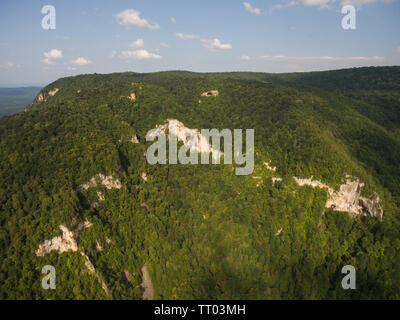 Foto fatte drone. Una vista di una grande collina boscosa con una grotta. Montagne del Caucaso. Foto Stock