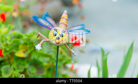 Una novità ornamento giardino posizionato su uno stelo in un letto di fiori in un giardino interno Foto Stock