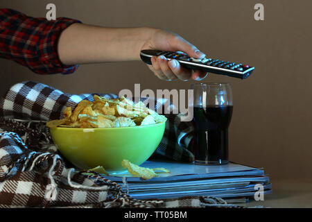 Chi guarda la TV con patatine e cola in camera Foto Stock