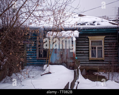 Grandi ghiaccioli sospesi dal tetto di una casa in legno, Russia Foto Stock