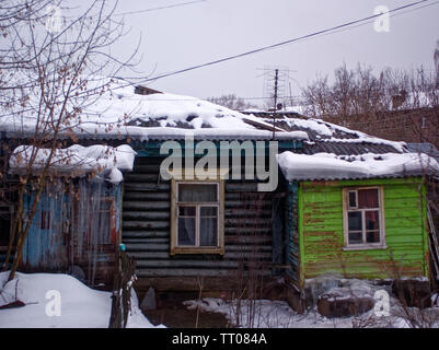 Grandi ghiaccioli sospesi dal tetto di una casa in legno, Russia Foto Stock