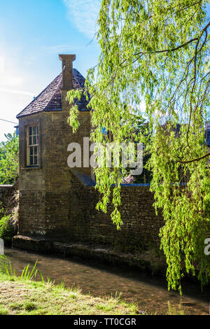 Un roundhouse in un piccolo vicolo noto come il Bow Wow che corre lungo un canale streamn nel villaggio Costwold di South Cerney nel Gloucestershire. Foto Stock