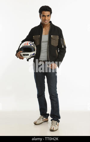 Biker holding a helmet under the arm and smiling Stock Photo