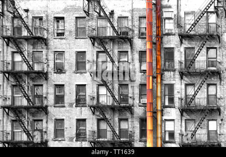 Bianco e nero appartamento edificio con colorata Vecchia arrugginita tubi metallici in New York City Foto Stock