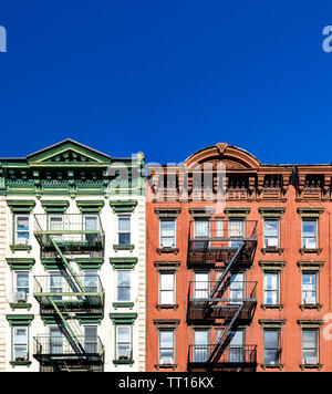 Vecchio di colore verde e rosso appartamento edifici con vuoto di cielo blu chiaro sfondo nell'Alfabeto città quartiere di Manhattan a New York City NYC Foto Stock