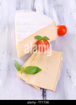 Gustoso formaggio Camembert con pomodoro e basilico, sul tavolo di legno Foto Stock