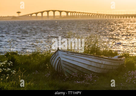 La svedese Oland ponte con un vecchio weathered barca a remi sulla terra nella parte anteriore Foto Stock