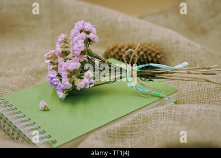 Rosa fiori secchi sul libro verde con una romantica impostazione vintage. Foto Stock