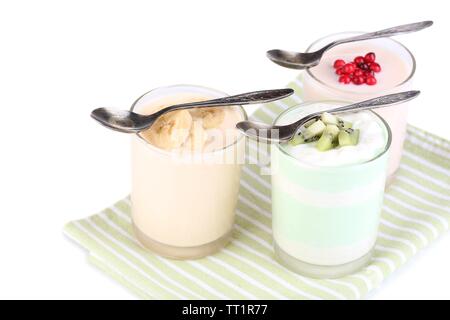 Delizioso yogurt con frutta gusti in bicchieri sul tovagliolo, isolato su bianco Foto Stock