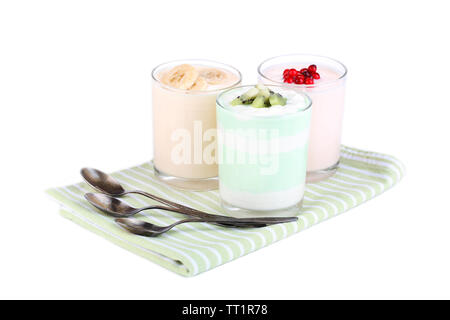 Delizioso yogurt con frutta gusti in bicchieri sul tovagliolo, isolato su bianco Foto Stock