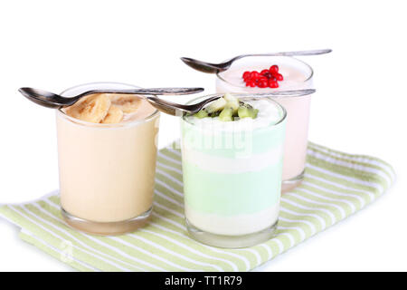 Delizioso yogurt con frutta gusti in bicchieri sul tovagliolo, isolato su bianco Foto Stock