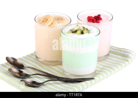 Delizioso yogurt con frutta gusti in bicchieri sul tovagliolo, isolato su bianco Foto Stock