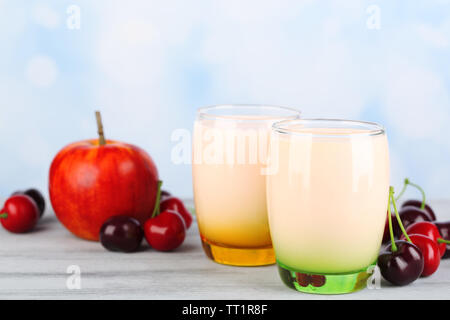 Delizioso yogurt con frutta gusti in bicchieri e frutta fresca sul tovagliolo, sul colore tavolo in legno, su sfondo chiaro Foto Stock