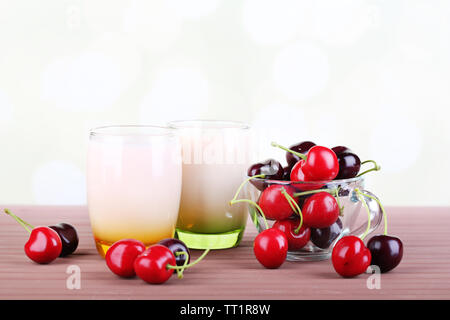 Delizioso yogurt con frutta gusti in bicchieri e frutta fresca sul colore di sfondo in legno Foto Stock