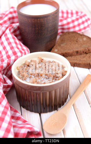 Bollito di grano saraceno con il latte in un recipiente sul tavolo di close-up Foto Stock