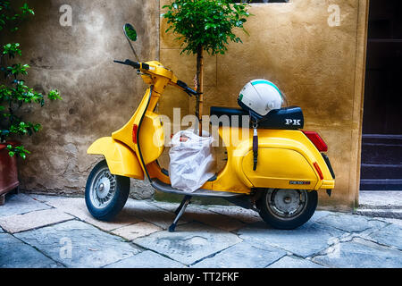 Vintage Sccooter con un piccolo albero parcheggiate lungo una casa, Pienza, Toscana, Italia Foto Stock