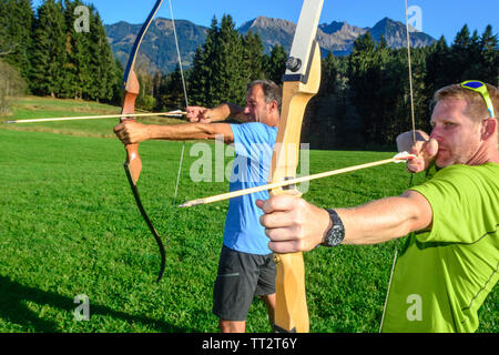 Persone che fanno il tiro con l'arco nel bellissimo paesaggio delle Alpi di Allgäu Foto Stock