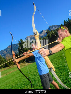 Persone che fanno il tiro con l'arco nel bellissimo paesaggio delle Alpi di Allgäu Foto Stock