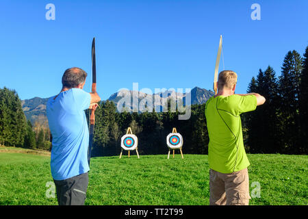 Persone che fanno il tiro con l'arco nel bellissimo paesaggio delle Alpi di Allgäu Foto Stock