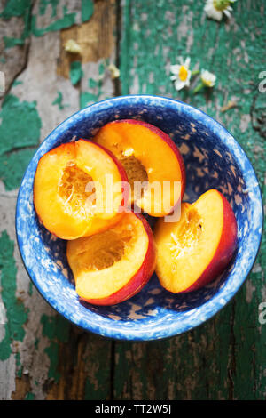 Tagliare le pesche noci frutti in vaso blu Foto Stock