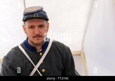 Uomo in uniforme dell'esercito confederato soldato seduto in accampamento militare durante la mosca festival storici 'volte ed epoche'. La guerra civile americana Foto Stock