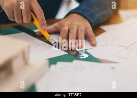 Un architetto di lavoro e il taglio di documenti di office Foto Stock