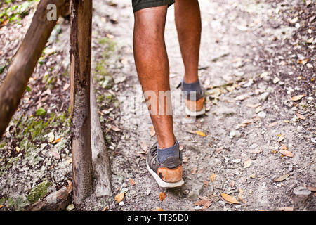 L uomo per le gambe sul parco o sentiero forestale con corrimano closeup. Bassa massa angolo di visualizzazione del livello. Foto Stock