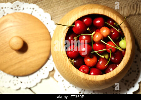 Ciliegie dolci nella ciotola sul tavolo di legno Foto Stock