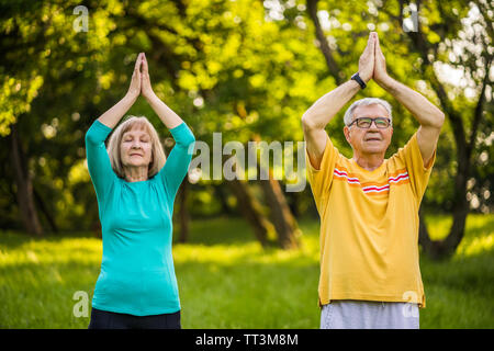 Coppia senior è meditando nel parco. Foto Stock
