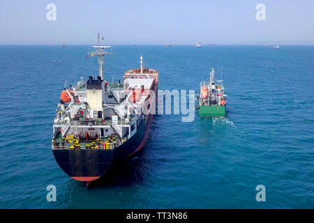 Il rifornimento di carburante in mare - Olio di piccoli prodotti di rifornimento di carburante della nave una grande nave portarinfuse, immagine aerea. Foto Stock