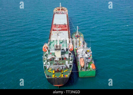 Il rifornimento di carburante in mare - Olio di piccoli prodotti di rifornimento di carburante della nave una grande nave portarinfuse, immagine aerea. Foto Stock