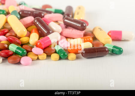 Pillole colorate splatter su sfondo bianco.Le diverse compresse e capsule heap terapia mix di droghe. Foto Stock