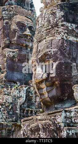 Un colpo di impatto dei rovinato antica facce sovrapposte al torri del tempio Bayon, situato presso l'ultima capitale dell'Impero Khmer - Angkor Foto Stock