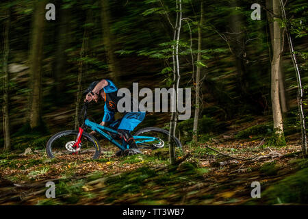 Un uomo corse in mountain bike sulla velocità di un sentiero attraverso il bosco in prossimità della città di Bristol nel sud ovest dell'Inghilterra. Foto Stock