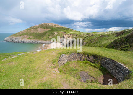 Robusto paesaggi costieri e la spiaggia nella pittoresca baia di Mwnt in Ceredigion, Galles, con una fornace di calce in primo piano Foto Stock