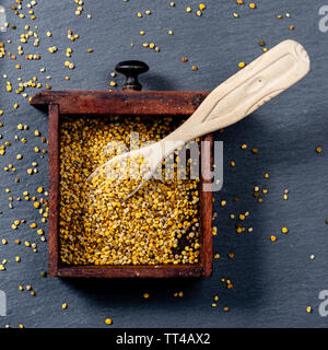 Close-up di api di granuli di polline all'interno di una piccola scatola di legno, visto da sopra Foto Stock