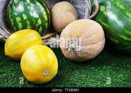 Di meloni e di angurie in vimini Cesto ovale su sfondo verde Foto Stock